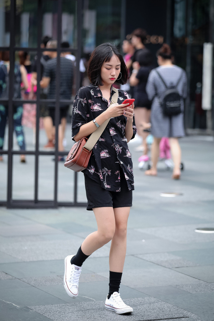 路人街拍：轻盈的小姐姐，黑色短裤秀出性感美腿，魅力十足