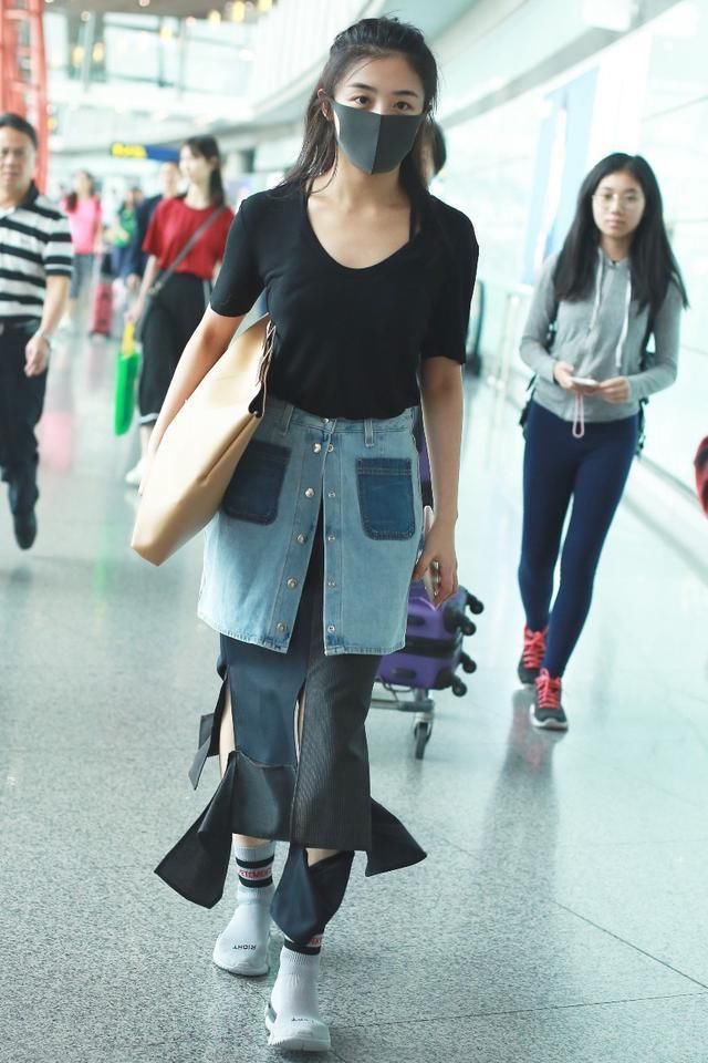 张含韵的时尚真难懂，不仅穿破裙子走机场，还在长裙外面套短裙！