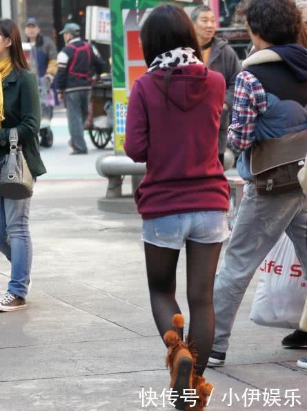 浅红色上衣搭配牛仔短裤黑丝袜的小姐姐,有着流行的头发