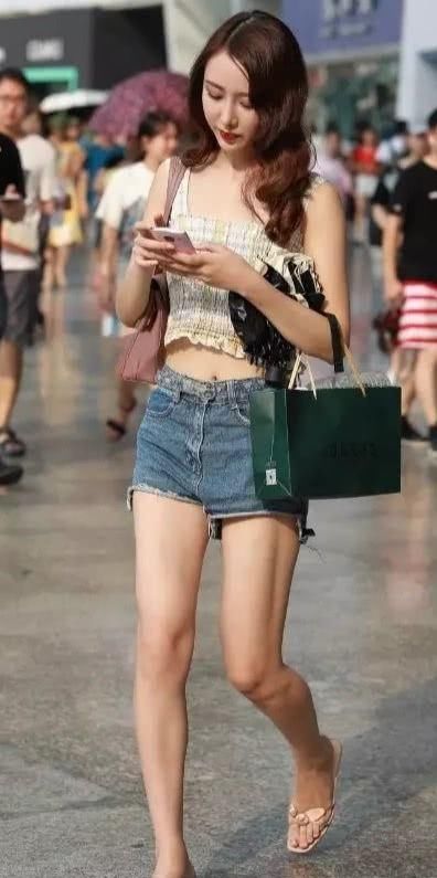  感觉：街拍：小姐姐深蓝色的牛仔色系热裤让人感觉非常的时尚抢眼