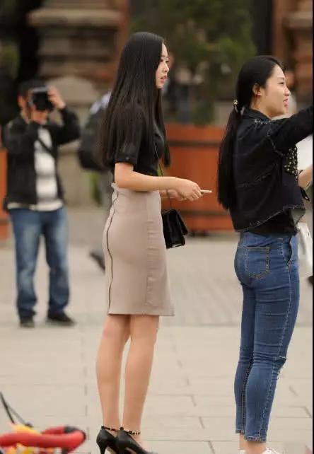 知性小姐姐紧身牛仔裤大秀性感身材，边走路边玩手机大胆奔放