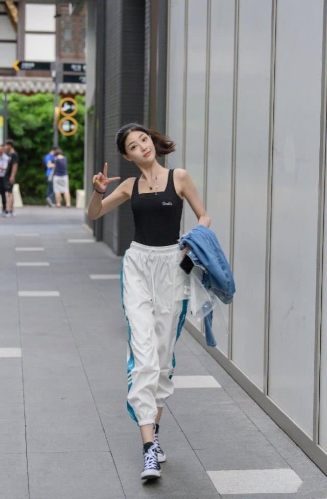  展现：街拍：美女化了漂亮的妆，吊带背心搭配阔腿裤，充分展现美丽大气感