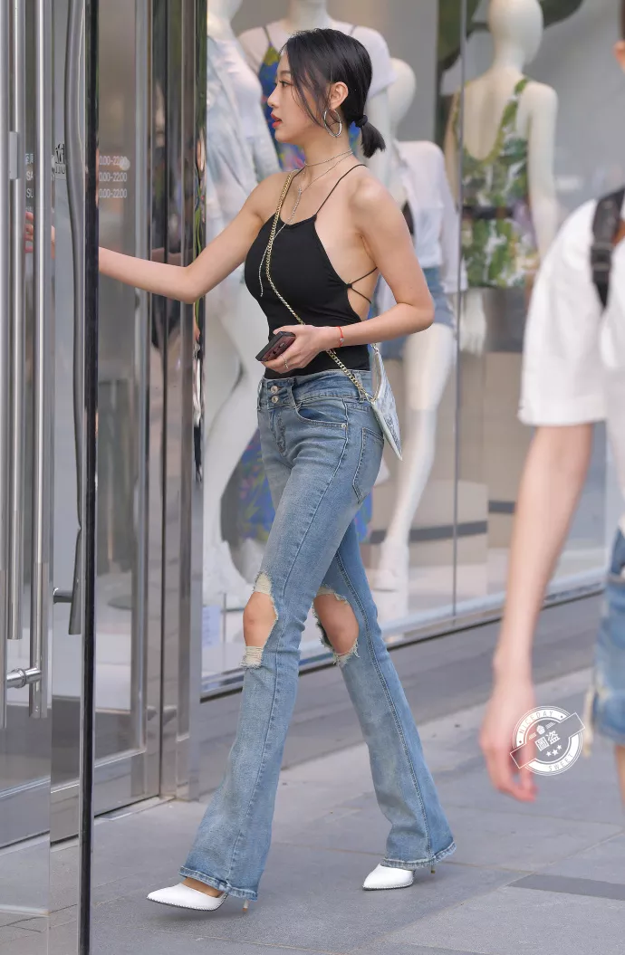 路人街拍，黑色上衣搭配牛仔裤，展示性感好身材，时尚潮流有魅力