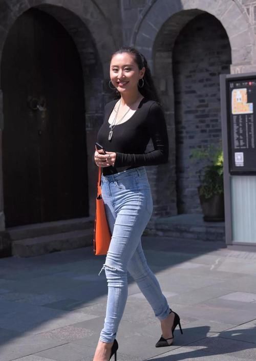 【美女】街拍牛仔紧身裤炫耀美腿,爆炸头的辣妹子,眼波流转动人不已