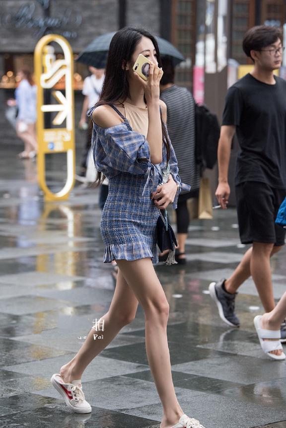 穿着紧身长裙，腿部开衩的设计让美女看起来格外的性感！