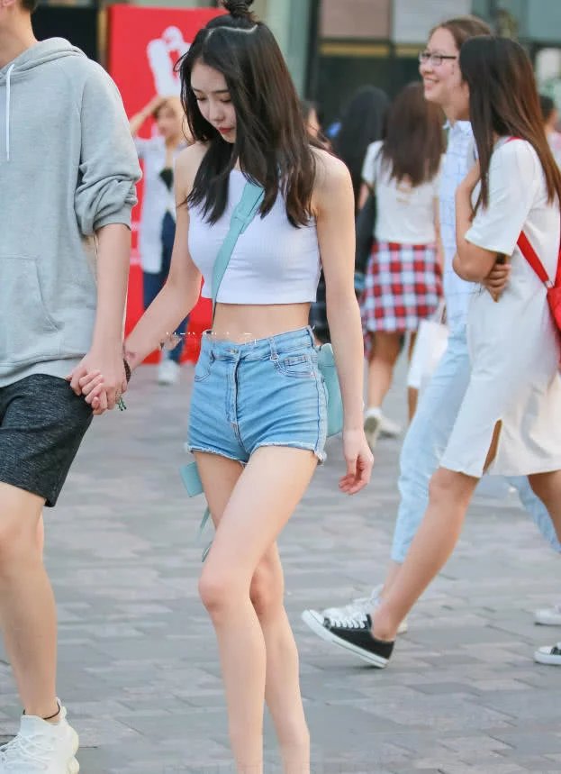 甜美小姐姐露脐装秀出白皙小蛮腰，超短裤裹出浑圆曲线，丸子头俏