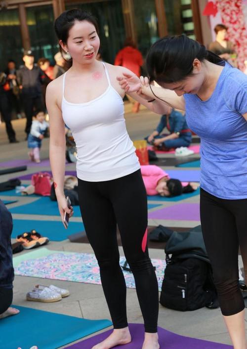 完美身段的紧身打底裤美女，搭配白色的吊带，颈部的纹身十分抢眼