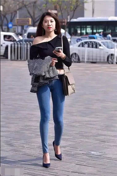 身穿紧身牛仔裤小姐姐，上身穿着黑色的黑色的露肩装，秀出来女人