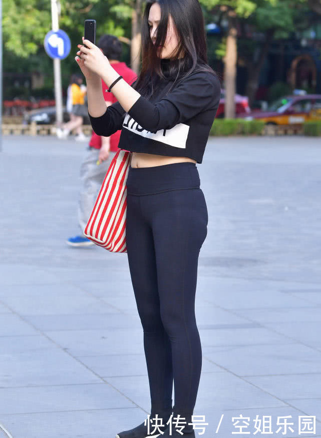 气质御姐紧身裤秀出凹凸有致好身材，街头凹造型的姿态赚足路人眼