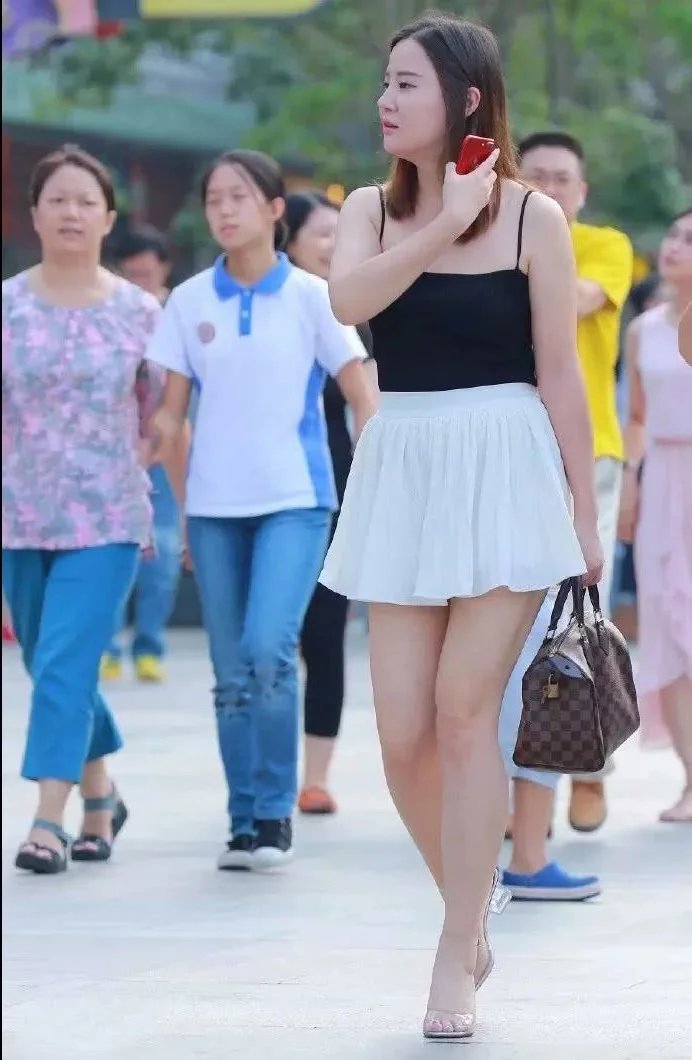 街怕微胖小姐姐性感吊带装，同时还展现了一双美腿