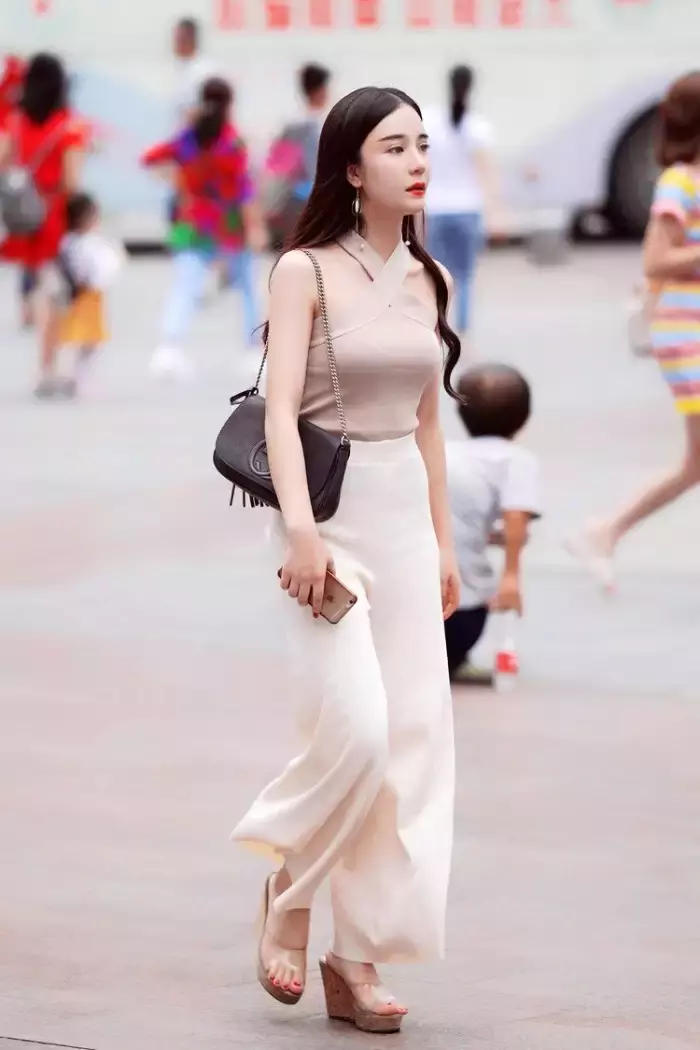 路人街拍，白色短袖搭配修身牛仔裤，突显好身材，带来不一样的美