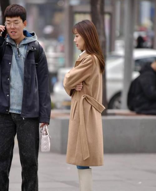  『蓝色』美女时尚街拍：身材高挑的美女，一件白色一字肩配蓝色牛仔裤，都市丽人范