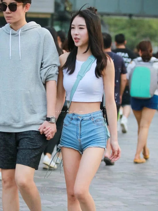 甜美小姐姐露脐装秀出白皙小蛮腰，超短裤裹出浑圆曲线，丸子头俏