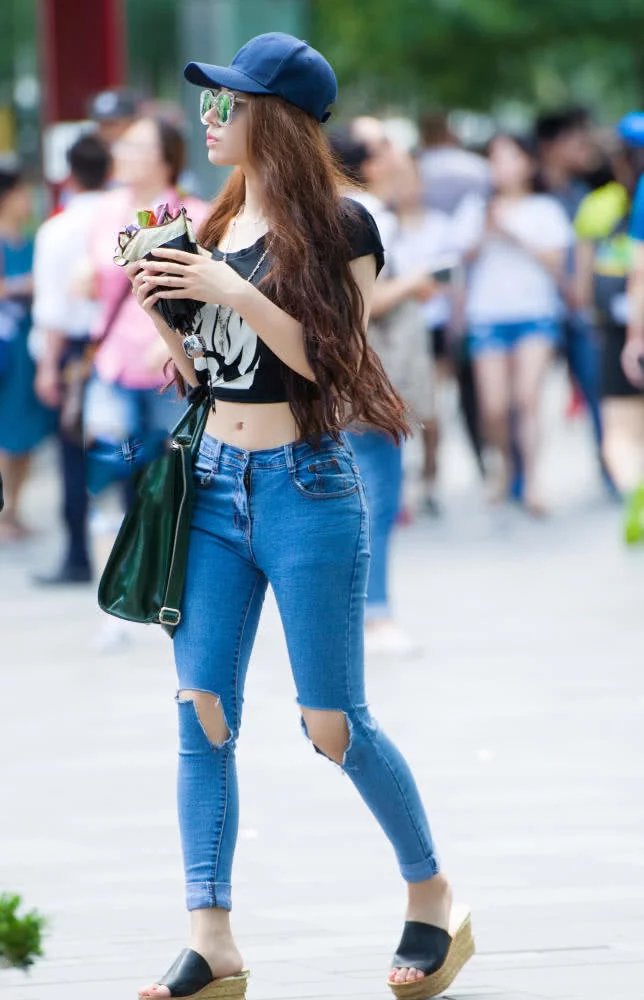 气质小姐姐紧身穿搭尽显迷人的身材曲线，紧身牛仔裤勾勒出浑圆臀