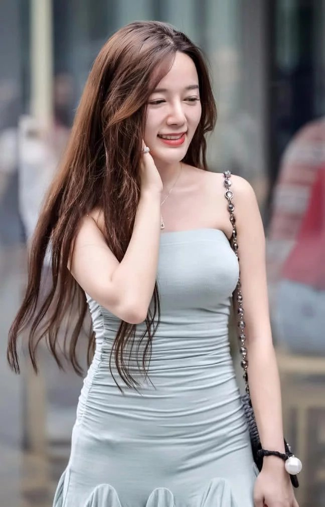 小姐姐身穿青色的迷你裙，一字肩的设计，使得小姐姐的颈部显得细