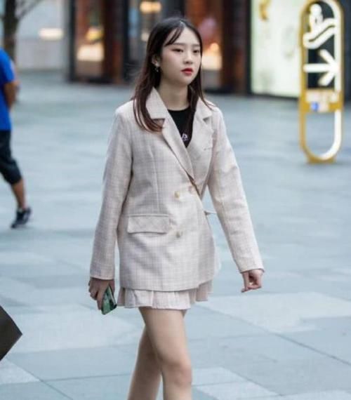 「紧身裤」街拍:身材苗条的美女,一件墨绿色上衣配黑色紧身裤,时尚气质