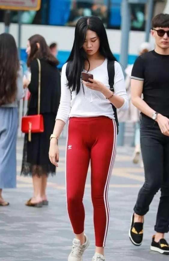 靓丽的红色紧身裤彰显圆圆的腿部线条，街头轻松吸睛无数