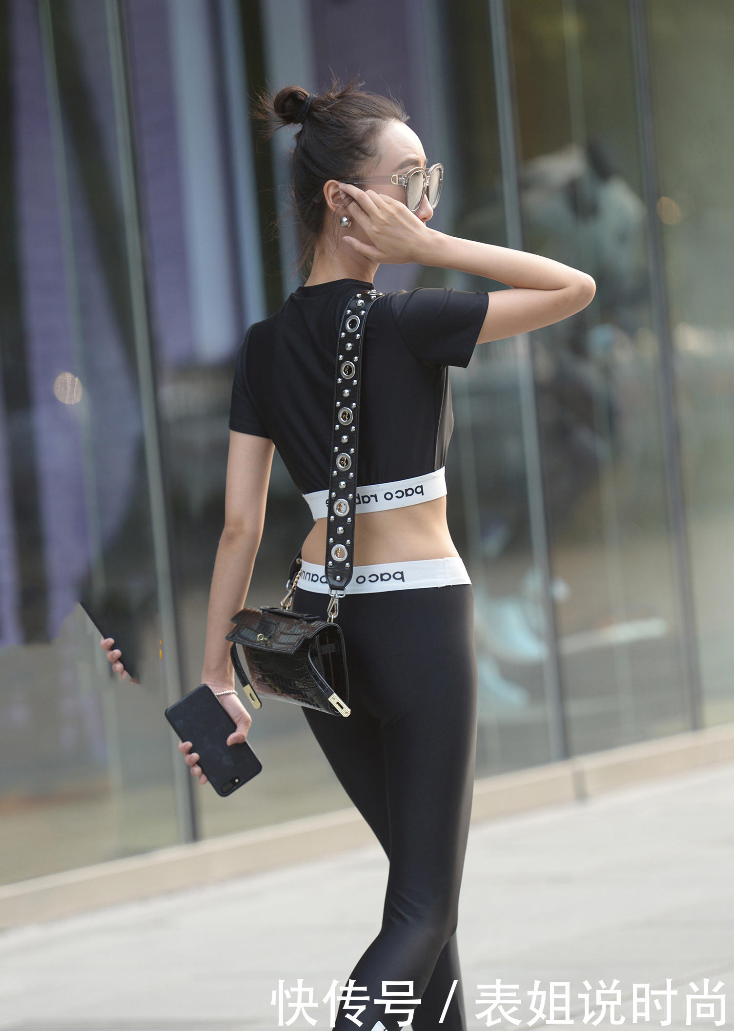 气质小姐姐一袭黑色紧身装秀出纤细身材，拿手遮脸的方式十分娇羞