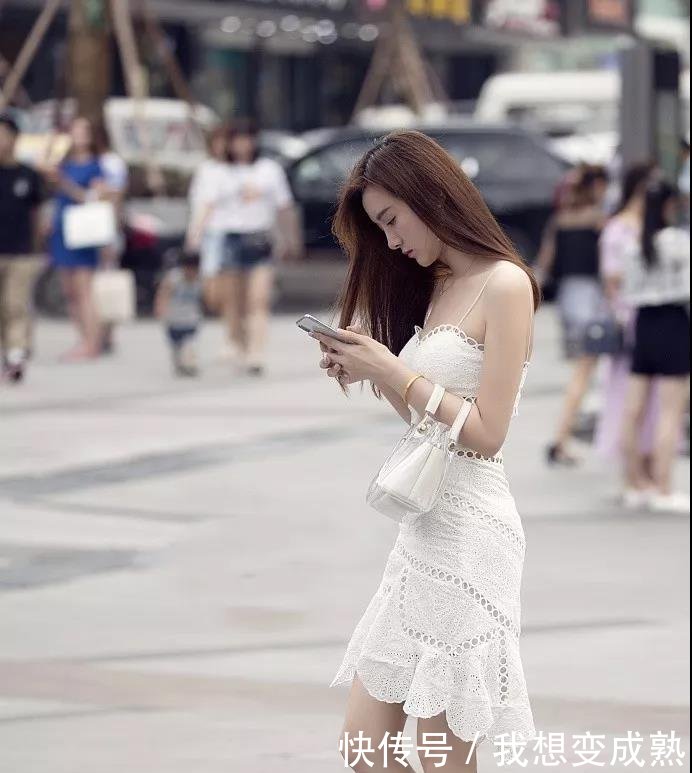 路人街拍，皮肤白皙的美女穿露脐装配紧身牛仔裤，身材妩媚而性感