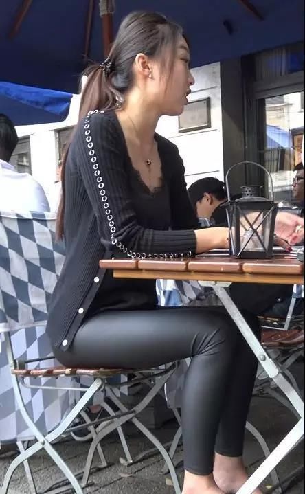 街拍:穿紧身黑皮裤绑马尾辫坐着的性感美女