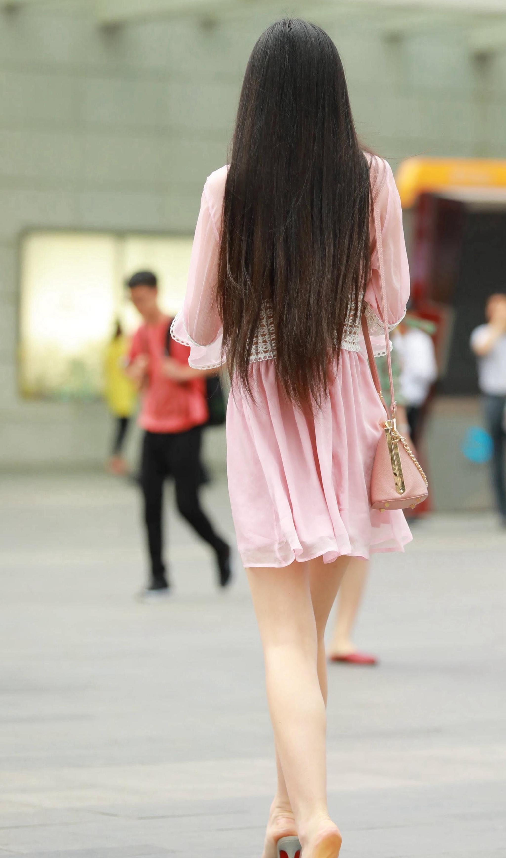 美女:穿着粉色连衣裙的美女,纤细白净的大长腿,真是惹人羡慕