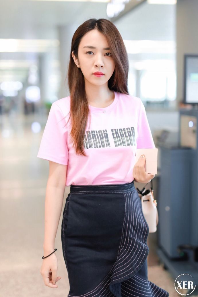 王晓晨穿粉色T恤搭配黑色荷叶边半身裙现身机场，少女感十足
