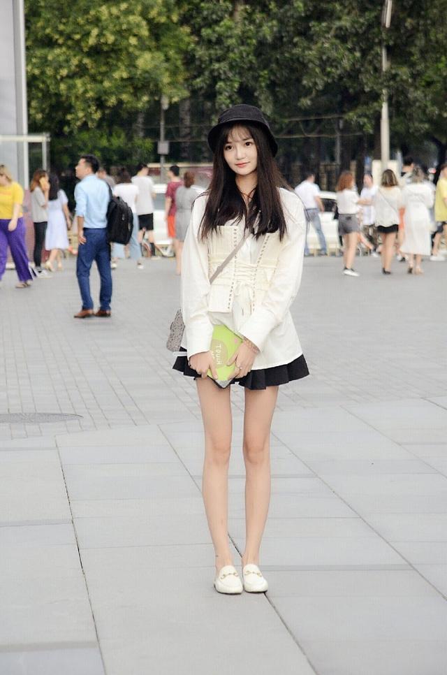 路人街拍，小姐姐身穿一件黑色的短裙，看上去非常的清纯可爱