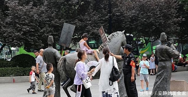 游客攀爬景区雕塑拍照,保安喊话劝告无效,沉默地递上一牌子