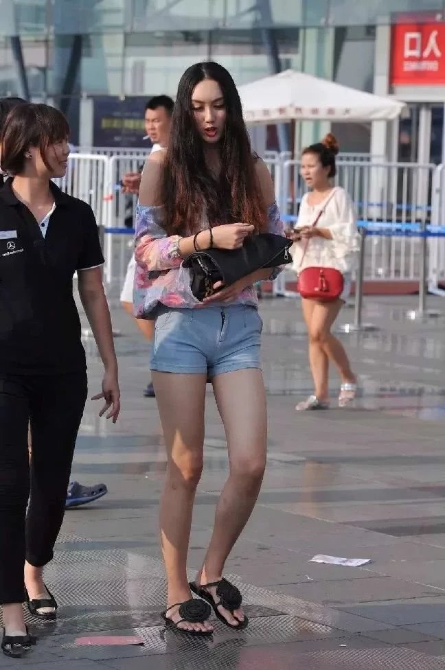 火车站偶遇长发气质小姐姐，吊带抹胸装搭配紧身短裤尽显高挑迷人