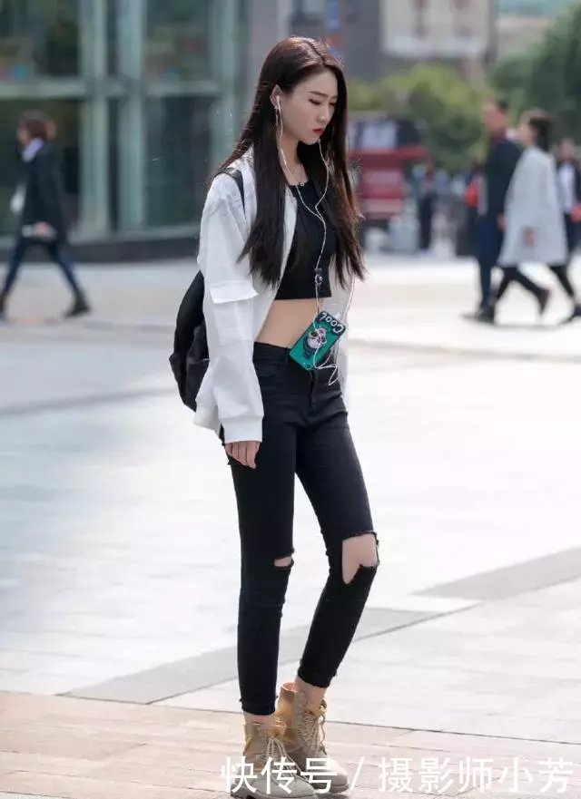 路人街拍，小姐姐身穿紧身的浅蓝色牛仔裤，勾勒出迷人的双腿