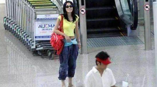 48岁王菲现身机场, 露脐装一片哗然, 网友: 丝巾当腰带够大胆!