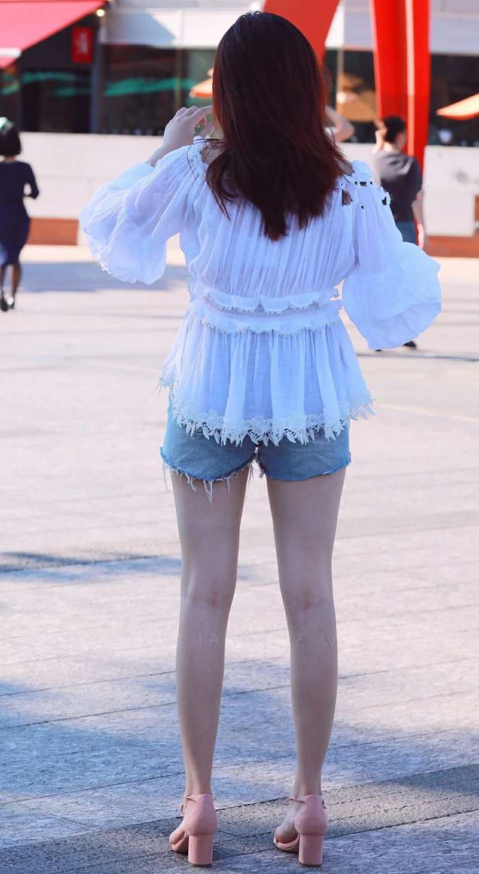 街拍：婴儿肥小姐姐牛仔短裤大秀时尚美腿，看到喷泉立马就玩嗨了