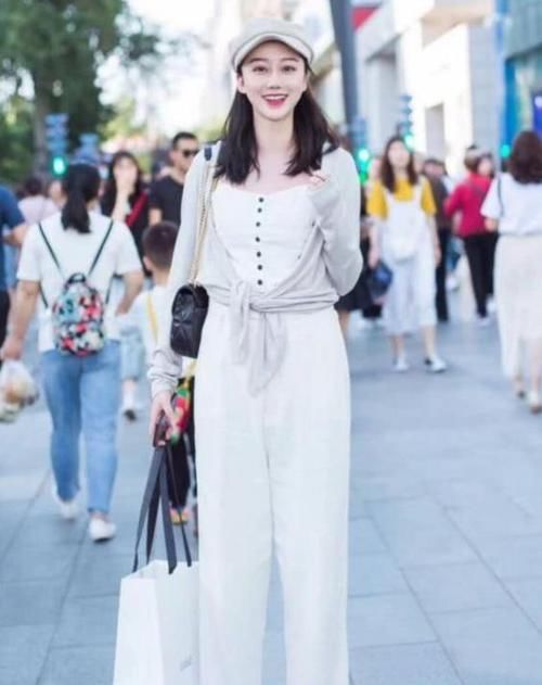 『连体』街拍:面带微笑的美女,一件白色连体裤外搭灰色开衫,时尚唯美