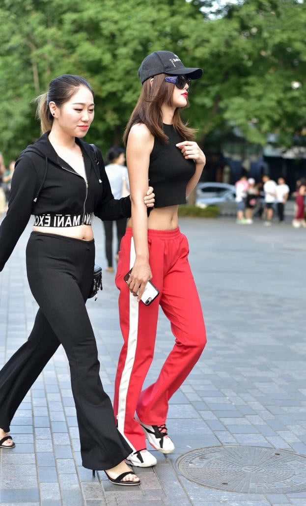 小姐姐紧身露脐装勾勒出丰满上围，平底鞋的穿搭，仍然比闺蜜高出