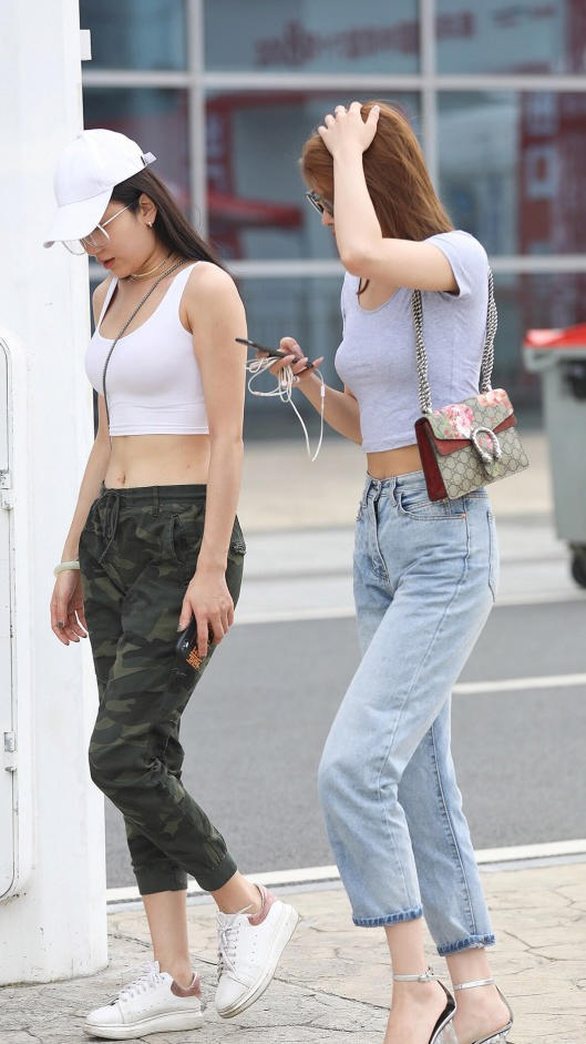 小姐姐军绿色的修身长裤尽显清爽干练的气质，身材高挑的闺蜜居然