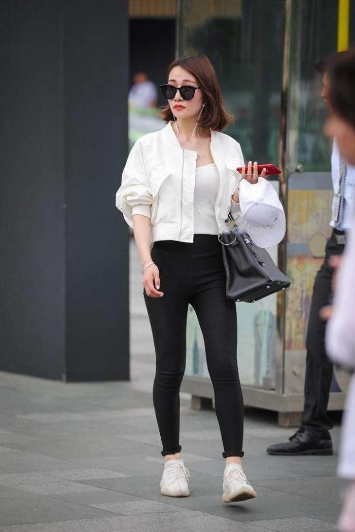 白上衣黑色紧身裤，既酷帅又不失女人味，这种感觉让人欲罢不能！