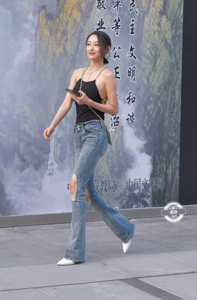 路人街拍,黑色上衣搭配牛仔裤,展示性感好身材,时尚潮流有魅力