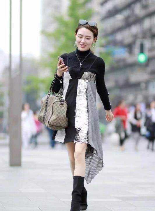 「低调」街拍:专注看手机的小姐姐,一字肩上衣+露洞牛仔裤,尽显低调冷艳的美