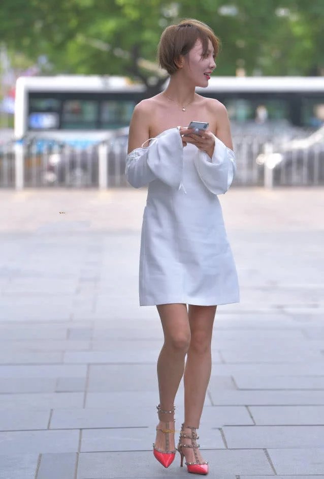 身穿白色抹胸连衣裤的小姐姐身材玲珑有致,怎么看都像披着一块浴