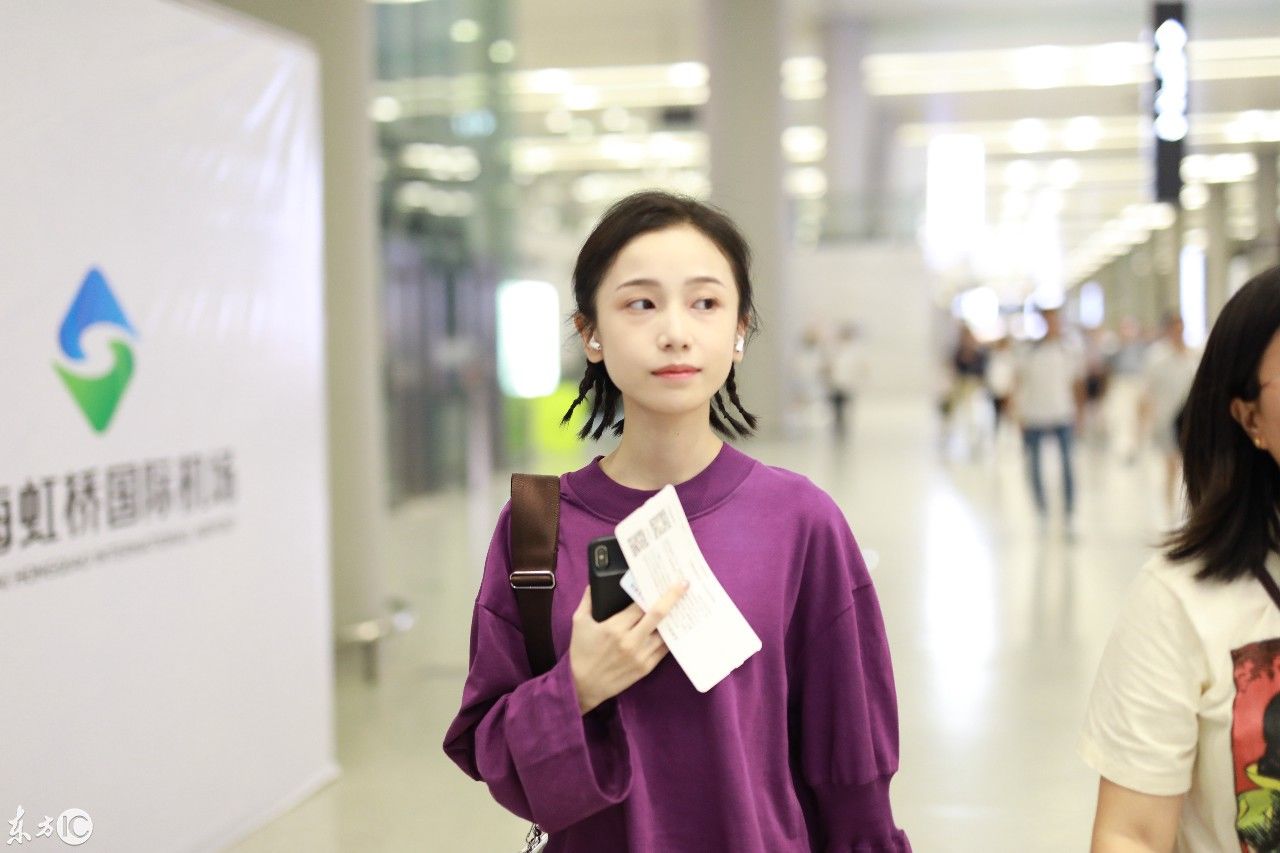 姜梓新穿紫色卫衣搭配黑短裤现身机场，皮肤白皙面带微笑大秀美腿