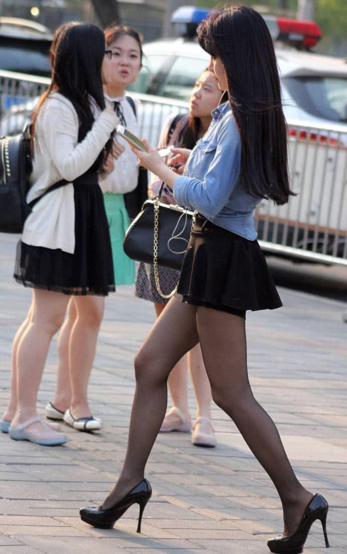 成熟少妇穿超短裙配黑丝袜高跟鞋，秀出一双纤细修长的美腿很有女