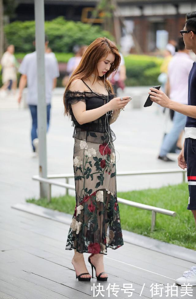 街拍：身穿薄纱吊带衣的小姐姐，胸前还开一个小口，美的很有别致