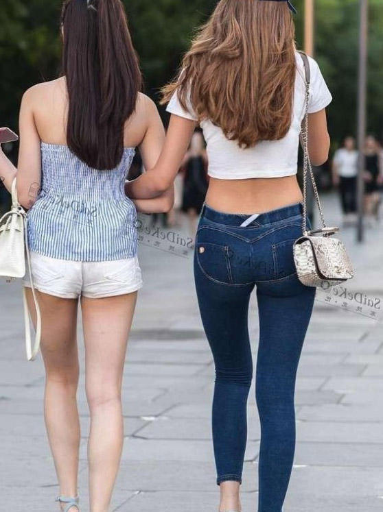 紧身裤小姐姐双腿修长，旁边的闺蜜则是一个超短裤，腼腆的笑容很