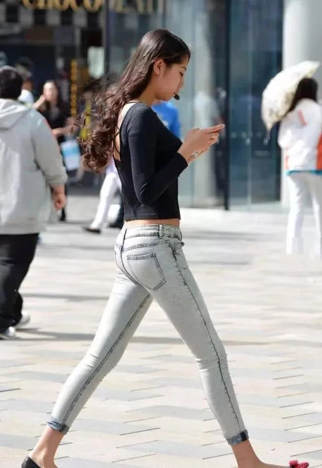 小姐姐披肩的卷发，透露的女神范儿，上身穿搭轻巧露背长袖，后肩