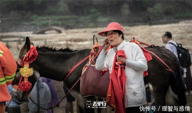 黄河瀑布边上的老汉牵毛驴给游客拍照，被拒绝也报以微笑