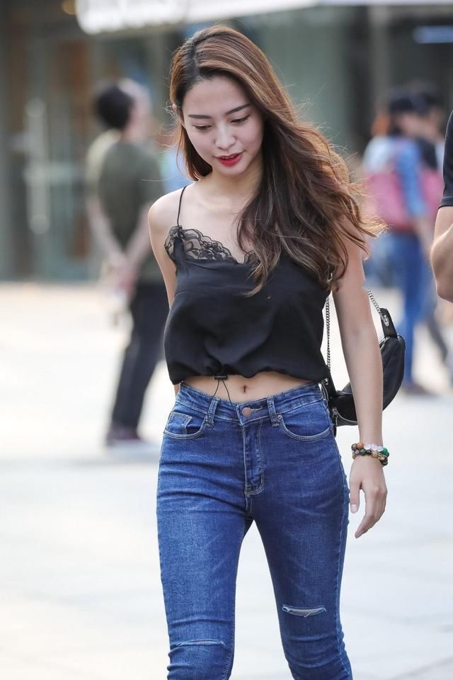长发美女紧身牛仔裤搭配黑色吊带，娇俏的容颜，气质甜美