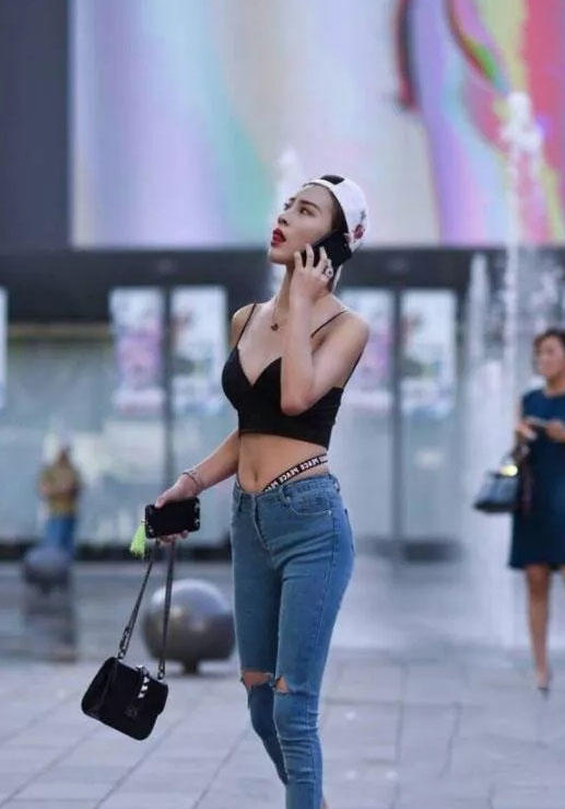 可爱萌妹吊带背心勾勒出凹凸有致的曲线，清爽效果极佳，破洞牛仔