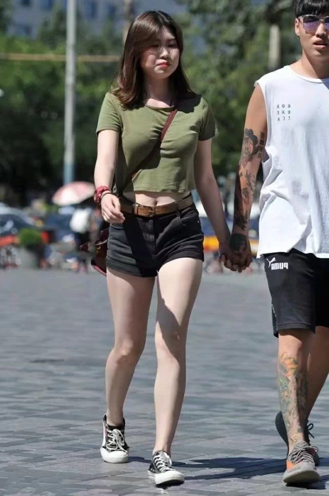 气质小姐姐紧身短裤尽显肥硕大腿，和小十岁男友牵手缠绵不顾路人