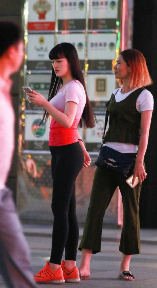 路人街拍,小姐姐穿了一件淡红色的T恤,十分的靓丽迷人