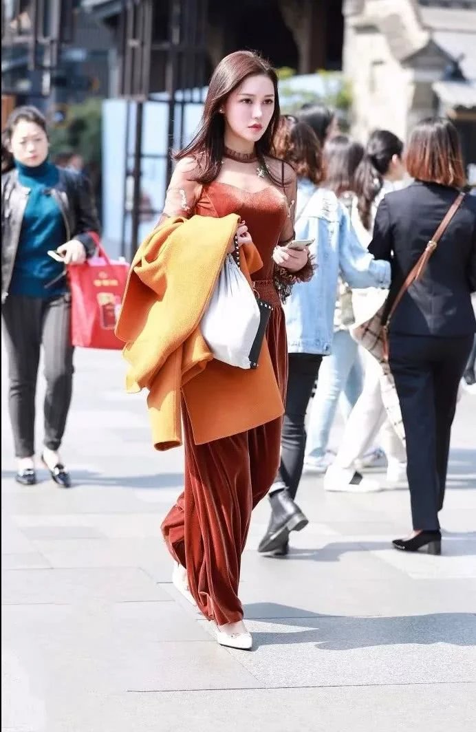 街拍身材饱满的性感美女，上身吊带的样子非常的性感迷人